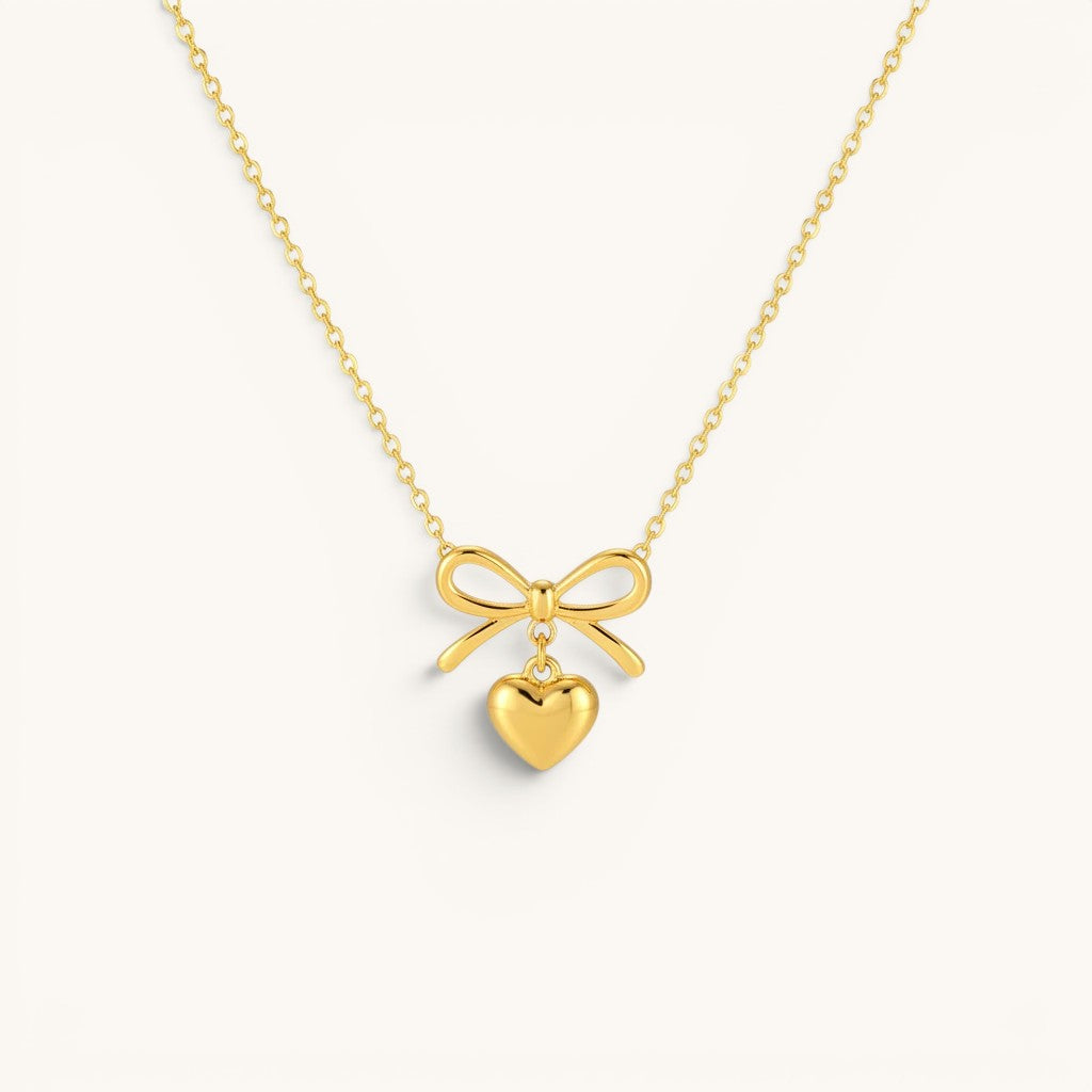 TITLIYA gold-tone necklace featuring a delicate bow pendant with a dangling heart charm for elegant daily wear.
