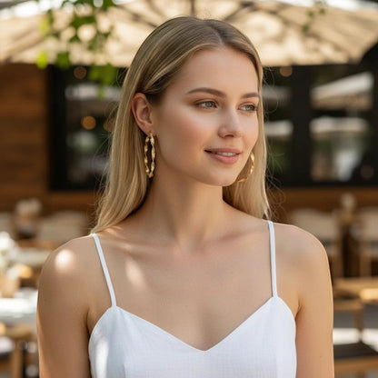 A woman wearing TITLIYA golden round twisted hoop earrings, perfect for daily elegance and special occasions.