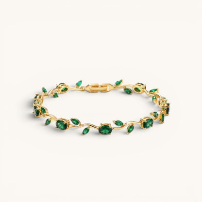 TITLIYA gold-tone vine bracelet featuring oval-cut green stones in a delicate botanical design.
