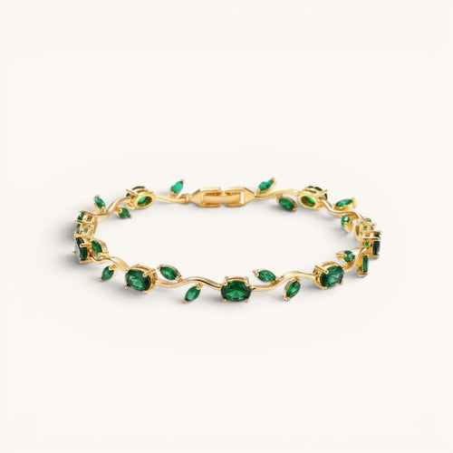 TITLIYA gold-tone vine bracelet featuring oval-cut green stones in a delicate botanical design.