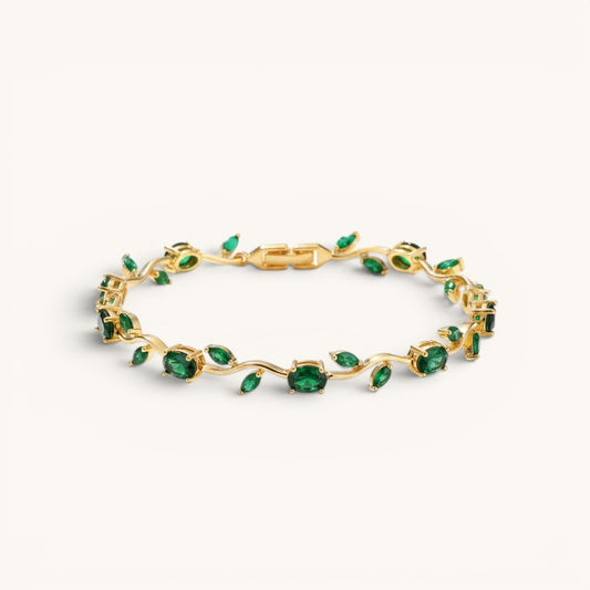 TITLIYA gold-tone vine bracelet featuring oval-cut green stones in a delicate botanical design.