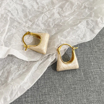 TITLIYA gold-toned hoop earrings featuring a unique cream-colored handbag shape for a stylish, elegant look.