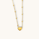 TITLIYA gold-tone heart pendant necklace featuring a delicate chain with small decorative beads for elegant daily wear.