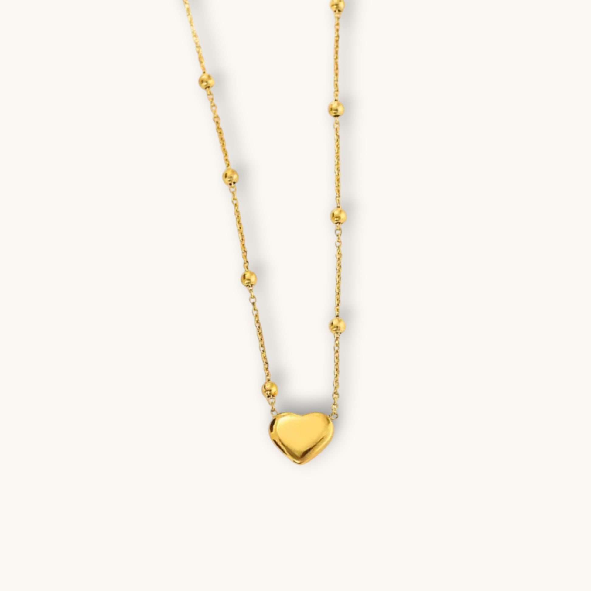 TITLIYA gold-tone heart pendant necklace featuring a delicate chain with small decorative beads for elegant daily wear.