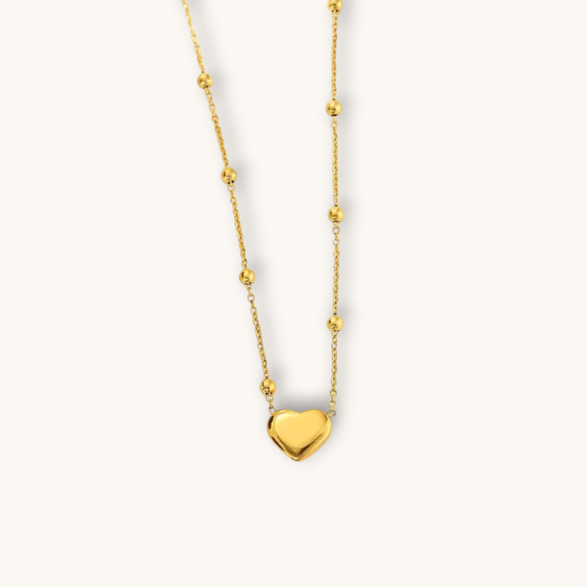 TITLIYA gold-tone heart pendant necklace featuring a delicate chain with small decorative beads for elegant daily wear.