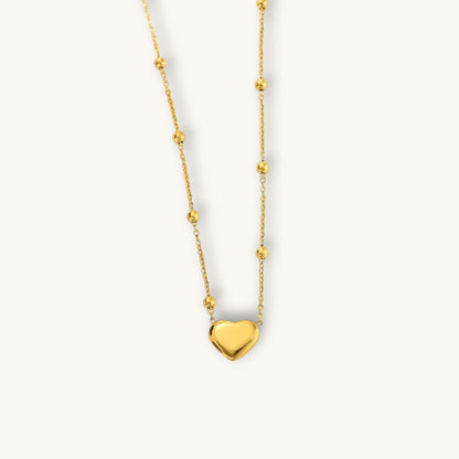 TITLIYA gold-tone heart pendant necklace featuring a delicate chain with small decorative beads for elegant daily wear.