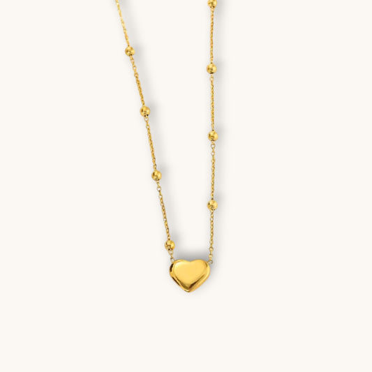 TITLIYA gold-tone heart pendant necklace featuring a delicate chain with small decorative beads for elegant daily wear.