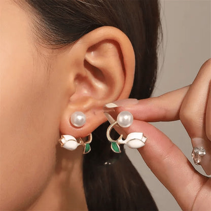 TITLIYA Korean-style earring featuring a white tulip bud, green leaf, and pearl stud worn on a model's ear.