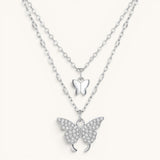 TITLIYA silver-tone layered necklace featuring a small smooth butterfly charm and a crystal-encrusted butterfly pendant.