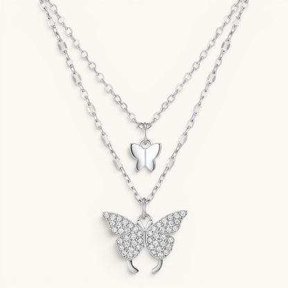 TITLIYA silver-tone layered necklace featuring a small smooth butterfly charm and a crystal-encrusted butterfly pendant.
