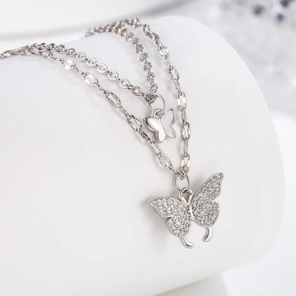 TITLIYA silver-tone layered necklace featuring a small butterfly charm and a crystal-encrusted butterfly pendant.