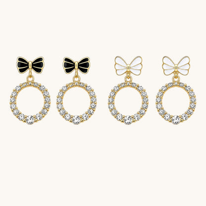 TITLIYA minimal bow earrings featuring gold-tone hoops with clear crystals and black or white enamel bow accents.