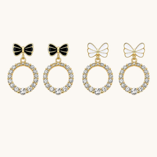 TITLIYA minimal bow earrings featuring gold-tone hoops with clear crystals and black or white enamel bow accents.