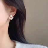 TITLIYA Pear Leaf Korean stud earrings featuring a white pearl and crystal-embellished leaf design on a model.