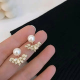 TITLIYA gold-tone Korean stud earrings featuring a white pearl and a crystal-encrusted leaf design for elegant wear.
