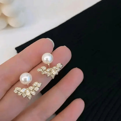 TITLIYA gold-tone Korean stud earrings featuring a white pearl and a crystal-encrusted leaf design for elegant wear.