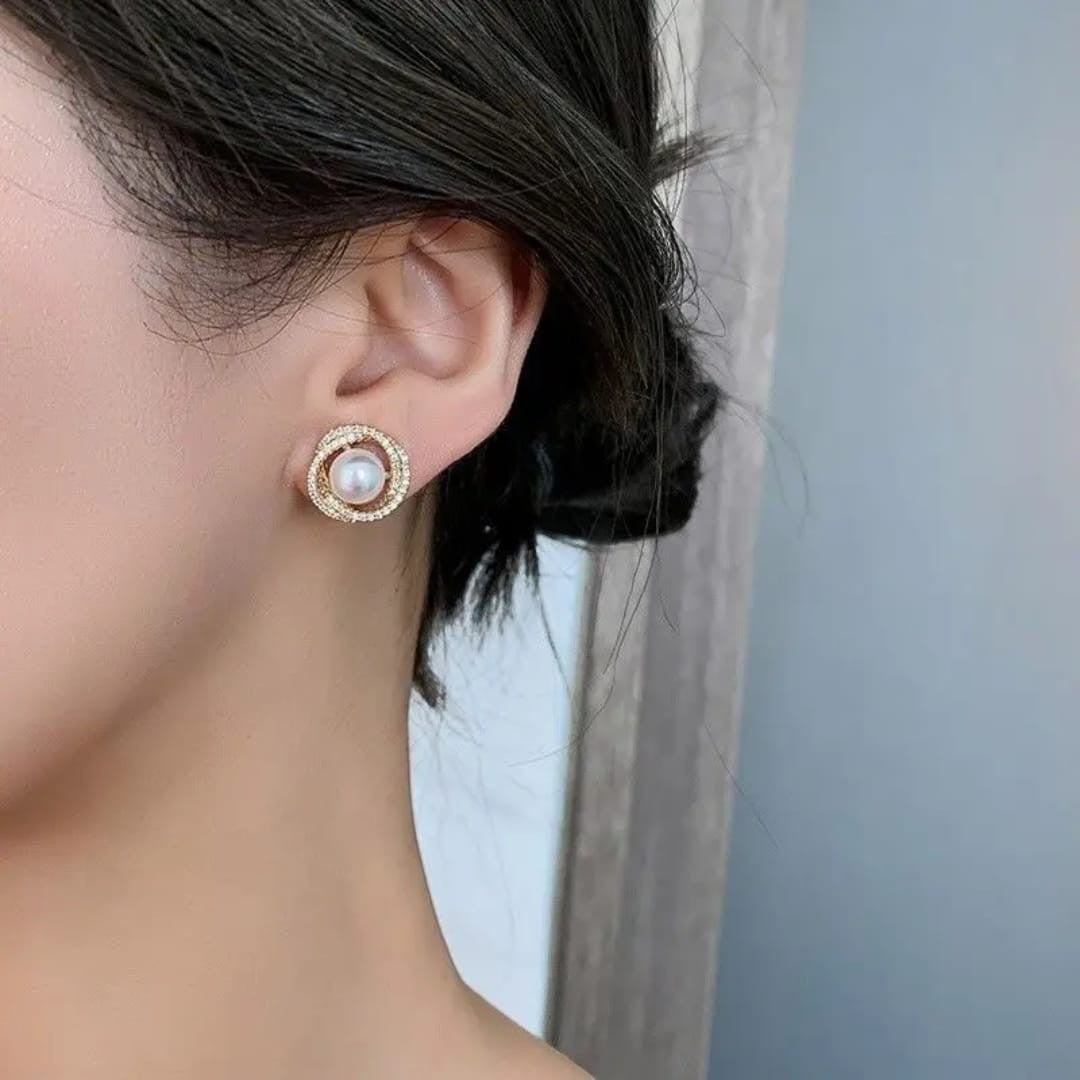 TITLIYA pearl and diamond stud earrings featuring a central white pearl surrounded by a sparkling halo on a model.