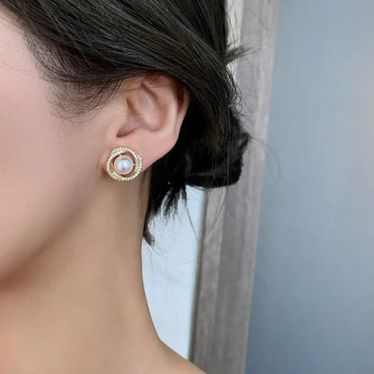 TITLIYA pearl and diamond stud earrings featuring a central white pearl surrounded by a sparkling halo on a model.