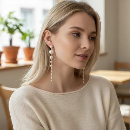 Woman wearing elegant TITLIYA pearl drop Korean hanging earrings with delicate chain details for a stylish look.