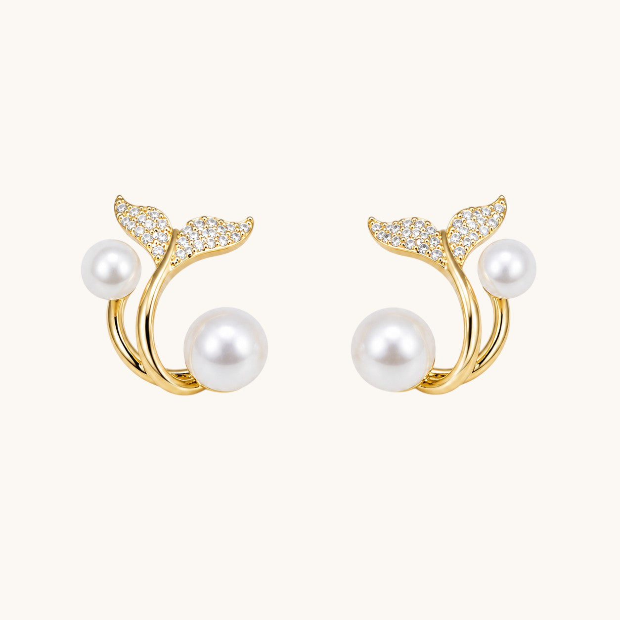 TITLIYA gold-tone whale tail earrings featuring white pearls and sparkling cubic zirconia accents.
