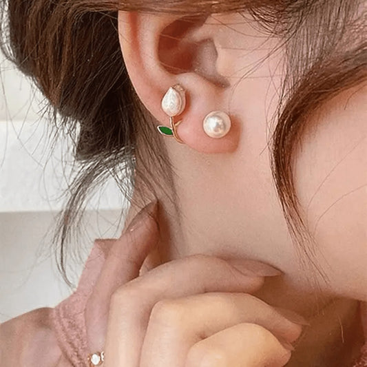 TITLIYA pink tulip and green leaf Korean stud earrings with pearl accents worn by a woman for an elegant look.