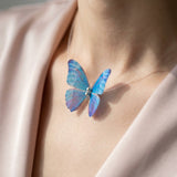 TITLIYA purple and blue butterfly choker necklace on a clear cord worn by a model in a silk top.