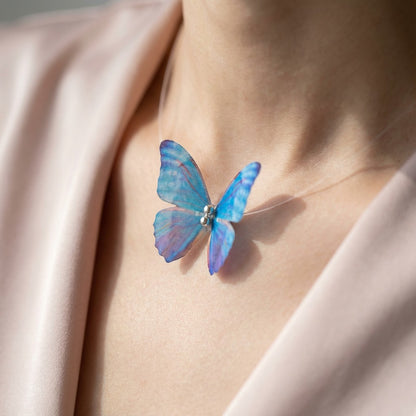 TITLIYA purple and blue butterfly choker necklace on a clear cord worn by a model in a silk top.