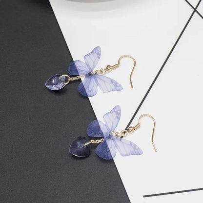 TITLIYA purple butterfly earrings with translucent wings and heart-shaped crystal drops on gold-tone hooks.
