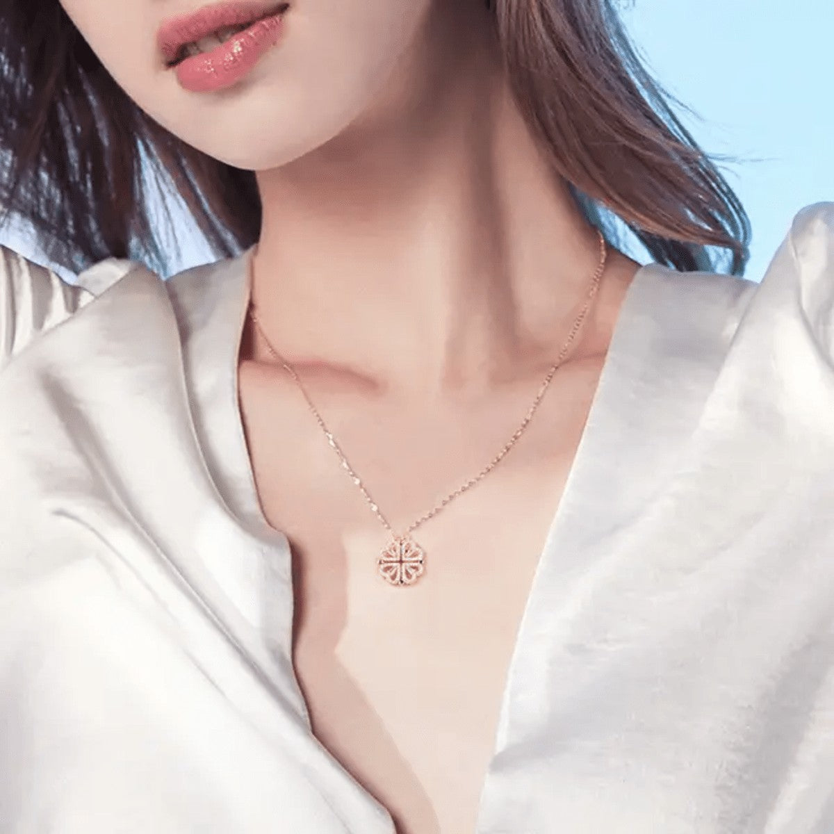 TITLIYA rose gold magnetic four-heart clover pendant necklace worn by a woman in a white satin blouse.