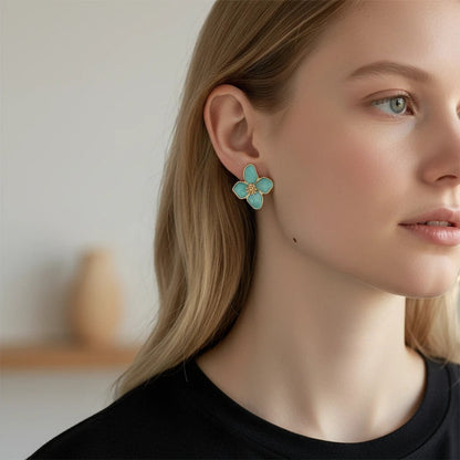 TITLIYA sea green enamel flower stud earrings with gold-tone center worn by a woman with blonde hair.