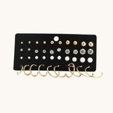 TITLIYA set of 20 earrings featuring gold studs, crystal rhinestones, white pearls, and small gold hoop earrings.