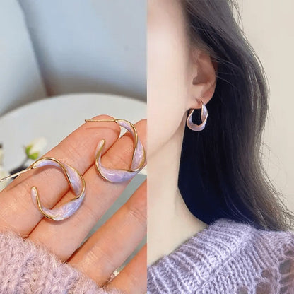 TITLIYA twisted Korean hoop earrings in lavender marble finish with gold trim, worn by a woman.