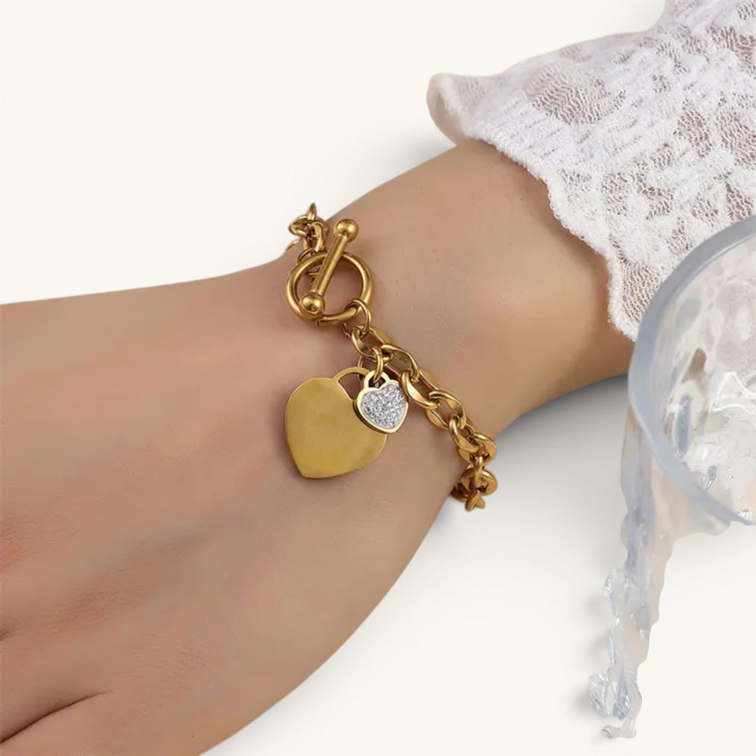 TITLIYA gold-tone chain bracelet featuring a polished heart and a crystal-encrusted heart charm with a toggle clasp.