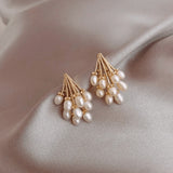 TITLIYA Korean-style gold-tone earrings featuring clusters of white water drop pearls on a soft grey satin background.
