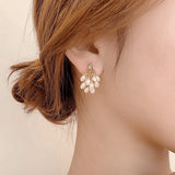 TITLIYA Korean-style water drop pearl cluster earrings in gold, worn by a woman for an elegant daily look.